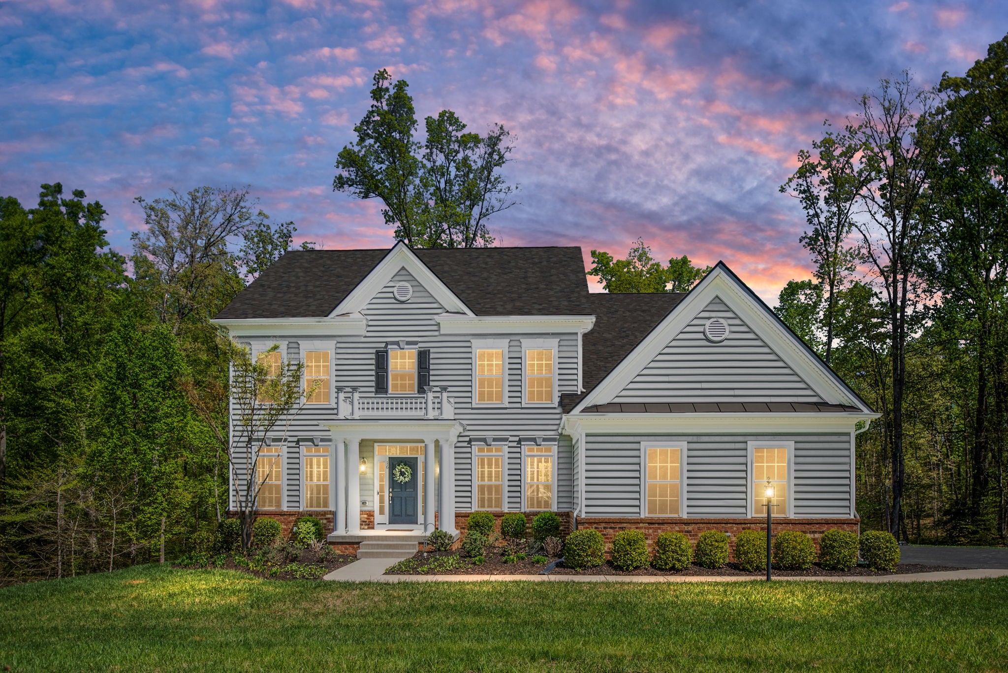 Classic colonial home with front walkway at sunset