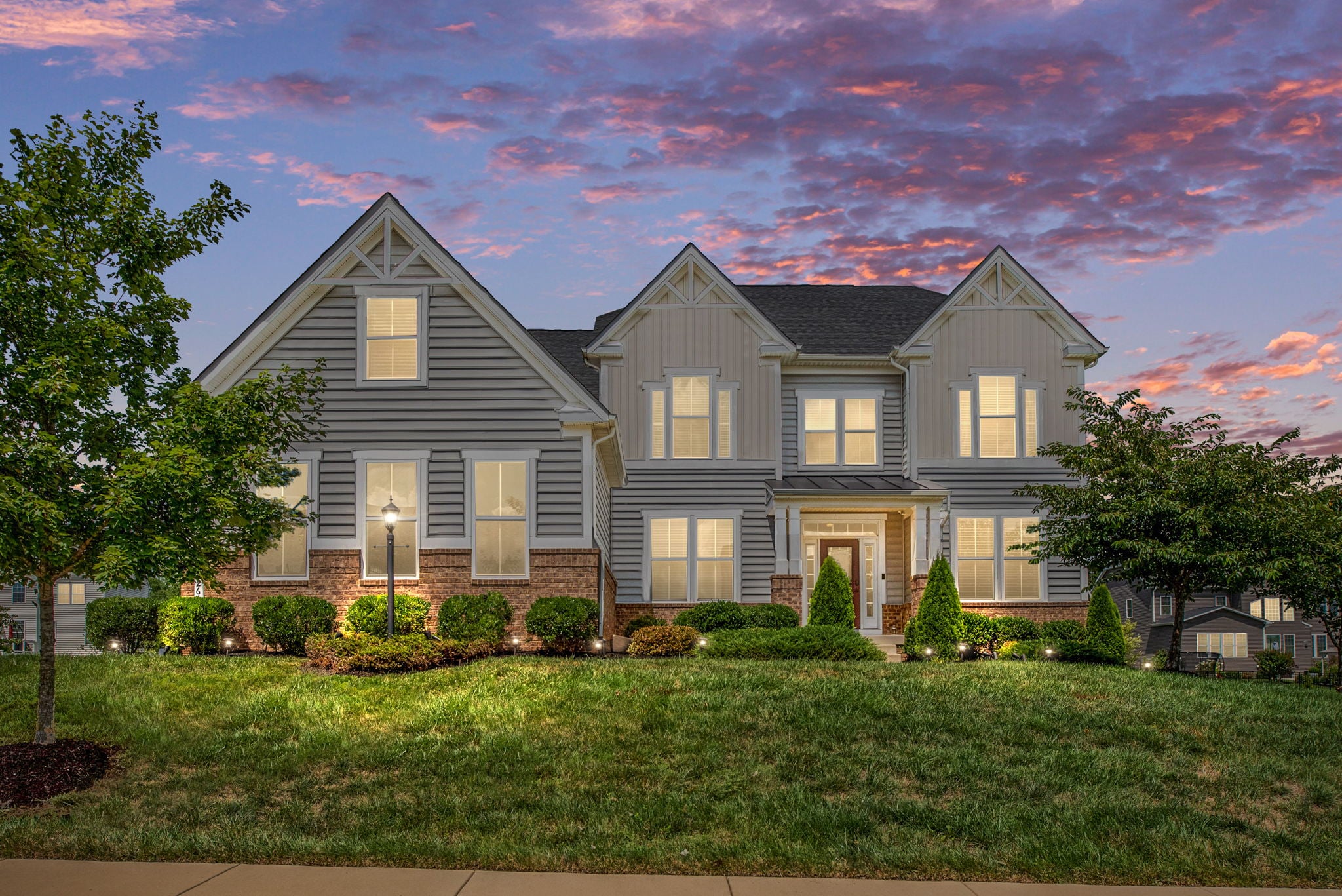 Craftsman home with landscape lighting at twilight